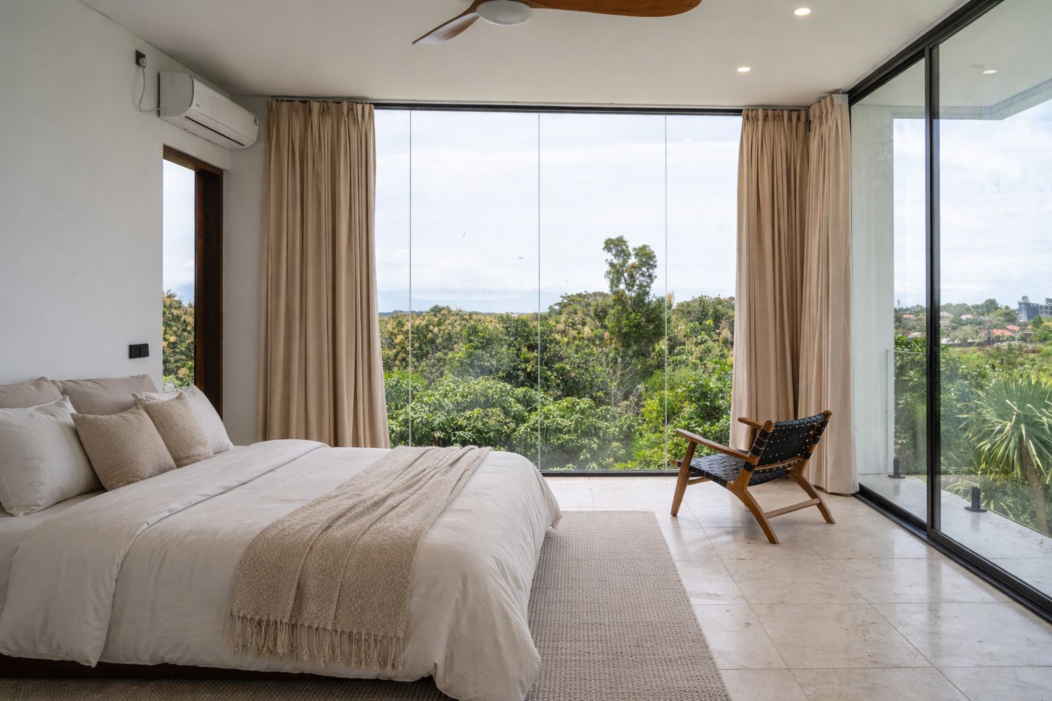 A bedroom turned to floor-to-ceiling glass and the Bukit treetops, a low bed and marble underfoot.